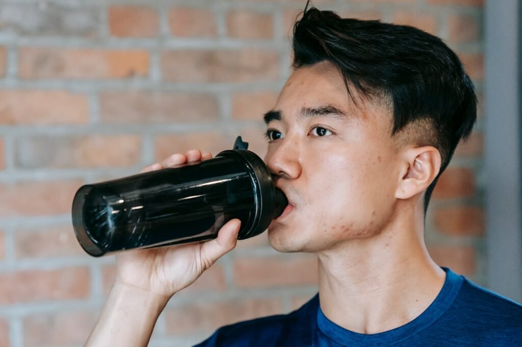 Creatine monohydrate vs micronized creatine: man drinking supplement out of shaker bottle